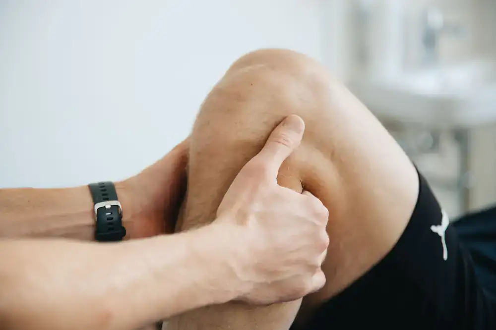 Physiotherapist examining an athlete's knee